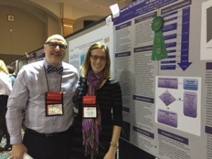 Two DNP students stand next to research poster