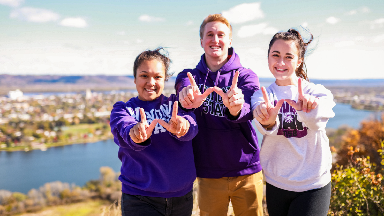 Three students making W's with their hands